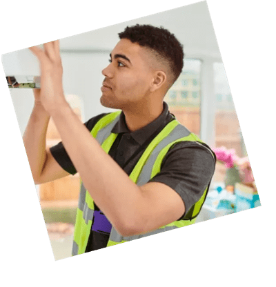 A boiler engineer in a hi-vis vest opening a cupboard