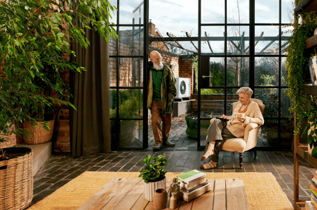 a man and a woman sit in a conservatory 